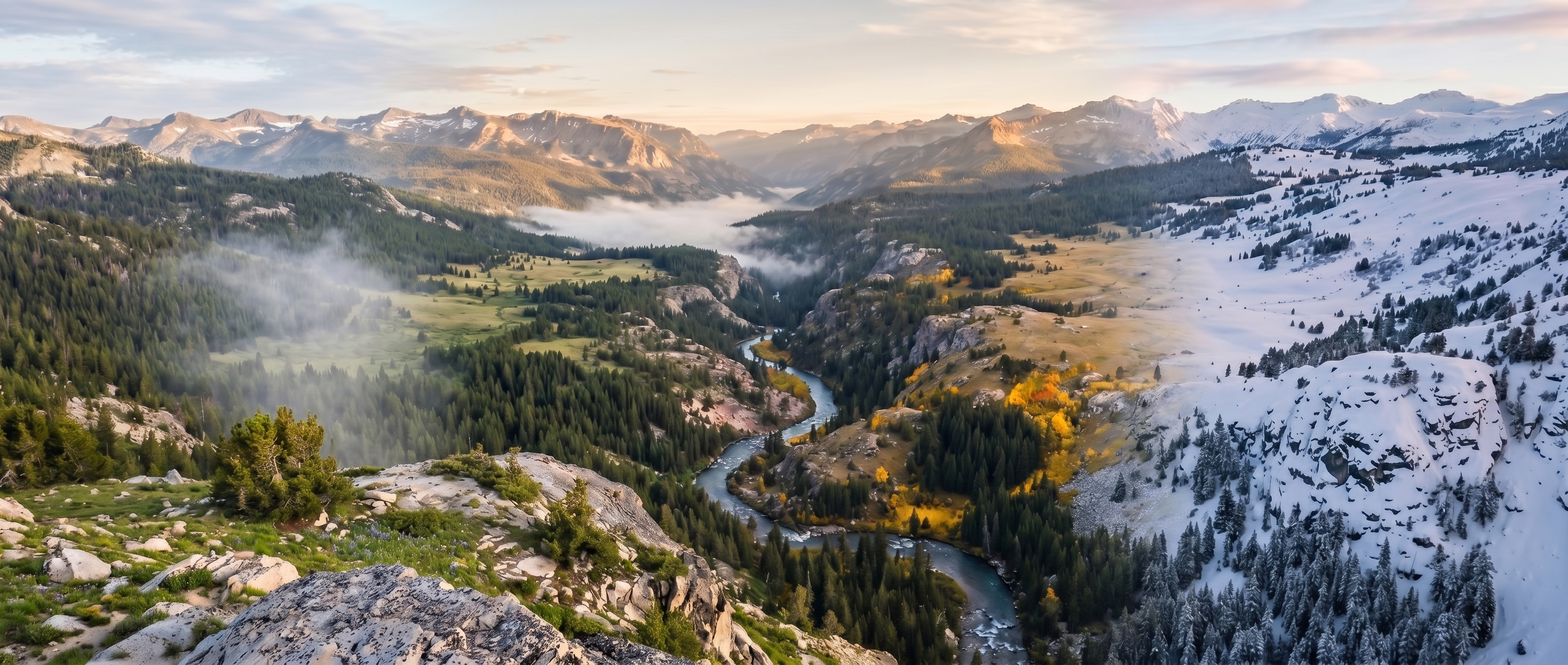 A high alpine valley spanning all four seasons — green meadows transitioning through autumn aspens to snow-capped peaks.